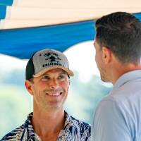 Michael Loney '92 talking to man in blue shirt